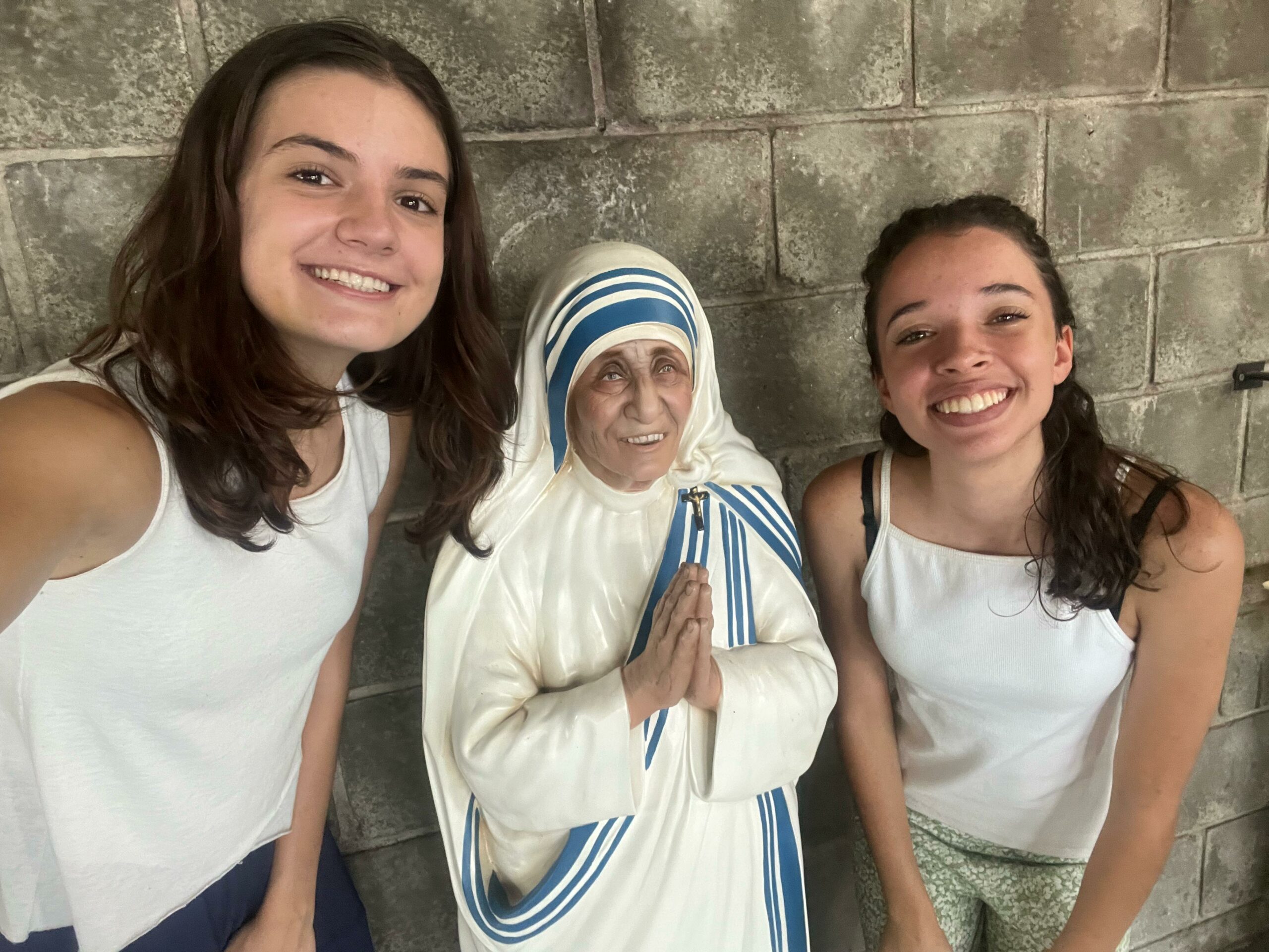 Estudantes Filomena Chiquetto do Lago e Gabriela Lopes Silva, ao lado de imagem de Madre Teresa de Calcutá